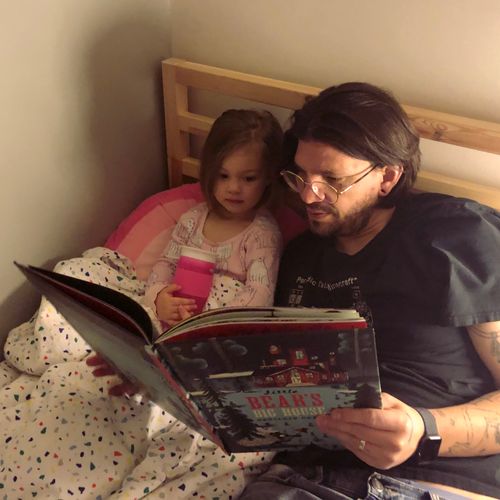 Dan reading bedtime stories to his daughter.