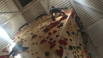 A picture of someone rock climbing inside of a building