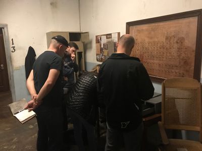 Multiple people in a locked room with a building map on the wall